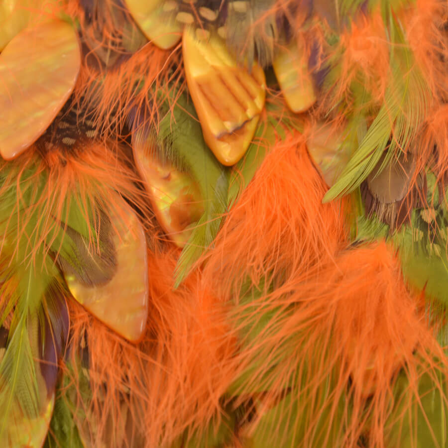 Adorno textil con plumas de colores y aplicaciones decorativas