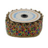 Pasamanería decorativa con piedras de colores y bordado dorado.