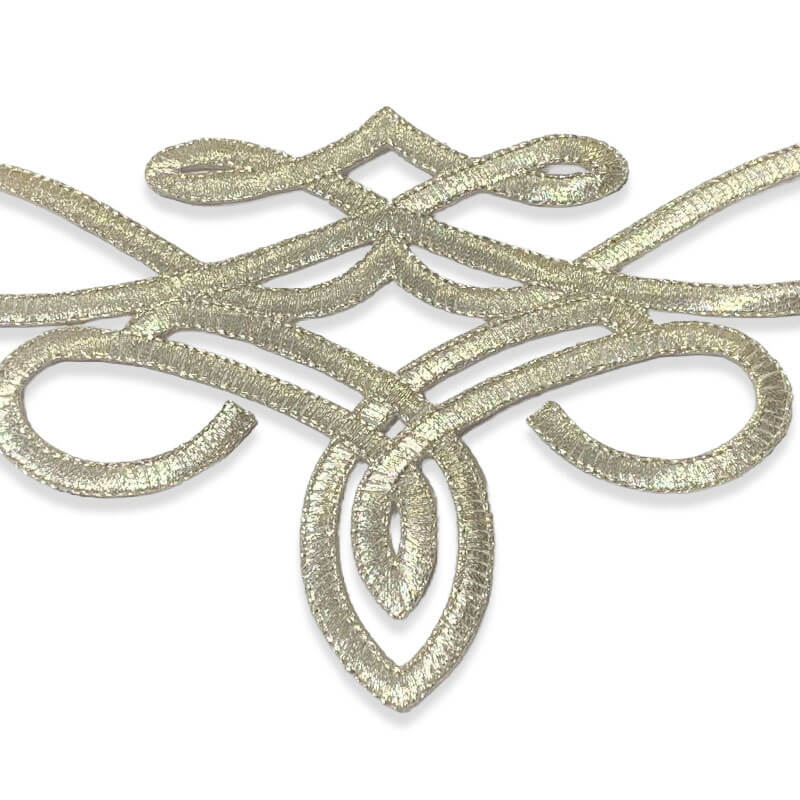 Detalle de aplique textil bordado en oro viejo para decoración de prendas