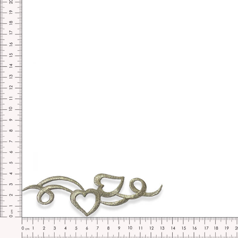 Detalle de aplique textil con diseño de corazón bordado oro viejo