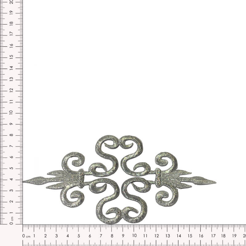 Detalle de aplique textil bordado plateado para decoración de prendas