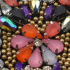 Detalle de aplique con piedras multicolor y acabado brillante