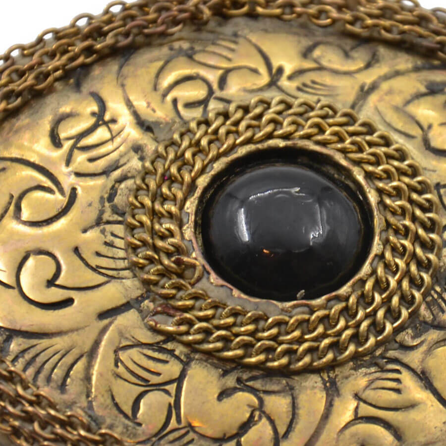 Colgante ovalado dorado con grabados ornamentales